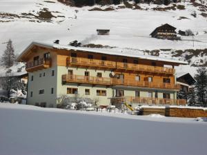 ein großes Gebäude im Schnee mit Schnee in der Unterkunft Ferienwohnungen Steidl in Innervillgraten