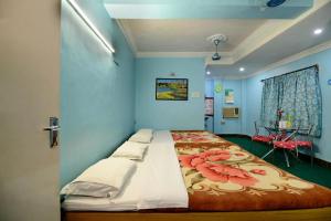 a bedroom with a large bed with blue walls at Hotel Airways in Kolkata