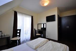 a bedroom with a bed and a desk and a television at Marcello Mielno in Mielno