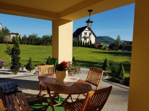 a patio with a table and chairs and a house at Nowy Domek Pod Kogutkiem in Górki Wielkie