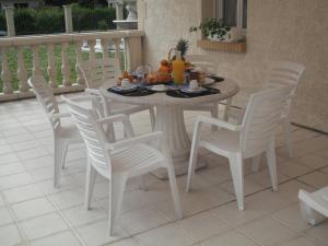 a white dining room table and chairs with food on it at Les chambres du lac in Forges-les-Eaux