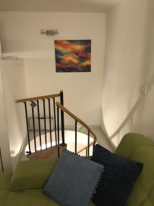a staircase with a green couch and a painting on the wall at Apartman Crnica in Šibenik