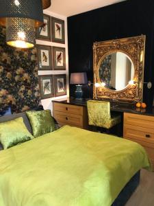 a bedroom with a green bed and a mirror at Secret Garden by Arder in Gdynia