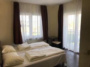 two beds in a room with windows and white sheets at Marcello Mielno in Mielno +6 photos