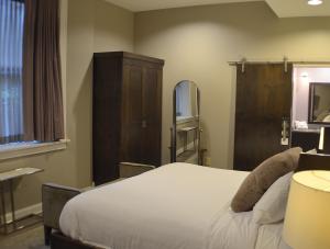 
a hotel room with a bed and a desk at Hotel at the Lafayette Trademark Collection by Wyndham in Buffalo
