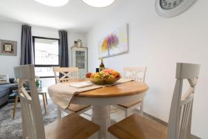 a dining room with a table with a bowl of fruit on it at King David 19 Apartment in Jerusalem