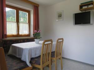 stół z dwoma krzesłami i wazonem kwiatów na nim w obiekcie Haus Buchsteiner w mieście Radstadt