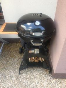 a grill sitting on a stand next to a wall at Apartman Za Potokem in Luhačovice