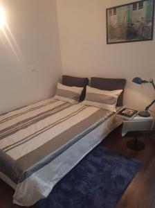 1 cama grande en un dormitorio con lámpara y mesa en Chic, 3 chambres pour maxi 6 juste aux Portes de Paris. Métro7, en Villejuif