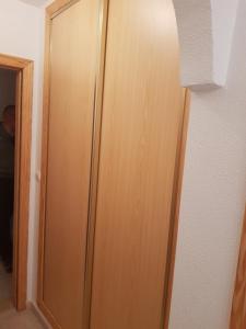 una puerta de madera en una habitación junto a una pared en SAL -Estudio a 200m de la playa del Cura en Torrevieja