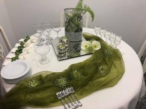 una mesa con platos y gafas y un mantel verde en Alojamento Requinte, en Oporto