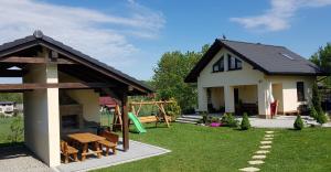 a small house with a playground in the yard at Nowy Domek Pod Kogutkiem in Górki Wielkie +16 photos