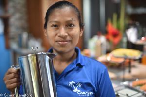a woman in a blue shirt holding a juicer at Oasis Bluff Beach in Bocas del Toro