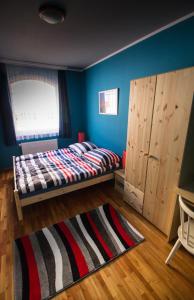 1 dormitorio con cama y pared azul en Boros Vendégház Eger, en Eger