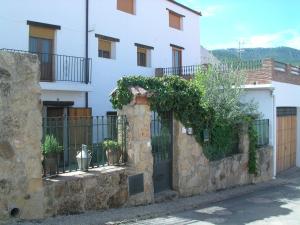 een huis met een stenen hek en een hek bij La Casa Del Valle in Cortijos Nuevos