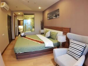 a bedroom with a large bed and a couch at Astra Suites Night Bazaar in Chiang Mai