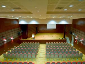 an auditorium with rows of chairs and a stage at Regiohotel Manfredi in Manfredonia +37 photos