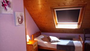 a small bedroom with a bed and a window at Gites de lardanva in Lardanva