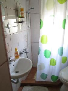 a bathroom with a sink and a shower curtain at Garden City Apartment in Cluj-Napoca