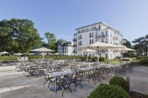 
a row of tables and chairs in front of a building at Steigenberger Grandhotel & Spa Heringsdorf in Heringsdorf
