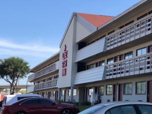 a building with cars parked in front of it at Lone Star Inn in Carrollton