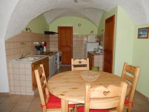 a kitchen with a wooden table and chairs in a room at Gîte Les Guérins in La Bâtie-Neuve