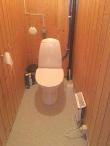 een badkamer met een wit toilet in een houten muur bij Kjekstadveien 22 Homborsund in Jordtveit