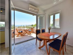 a dining room with a table and chairs and a balcony at Apartments Golub in Cesarica