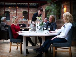 a group of women sitting at a table with wine glasses at Blåsingsborgs Gårdshotell in Kivik