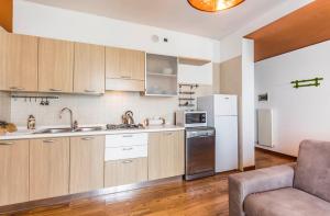 una cucina con armadi in legno e frigorifero bianco di Novalesi Apartment a Noale