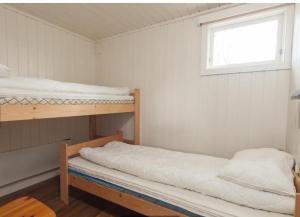 two bunk beds in a room with a window at Kjekstadveien 22 Homborsund in Jordtveit