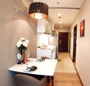 a small kitchen with a white table and chairs at Astra Suites Night Bazaar in Chiang Mai