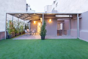 a backyard with a patio with green grass at Acropolis Stay in Athens