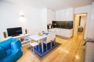 een keuken en een woonkamer met een tafel en een blauwe bank bij LivingPorto Apartments by Porto City Hosts in Porto
