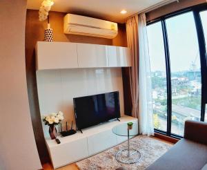 a living room with a flat screen tv on a wall at Astra Suites Night Bazaar in Chiang Mai