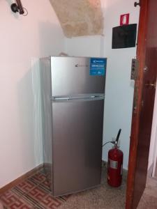a stainless steel refrigerator in a corner of a room at La casa di Adele in Syracuse