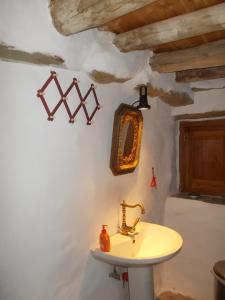 a bathroom with a sink and a mirror on the wall at Cyclades Olive Museum's Guest House in Pitrofós