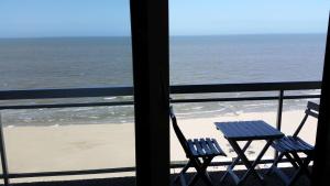 
a beach area with chairs and tables and a view of the ocean at Studio On The Beach With Sea View in Middelkerke
