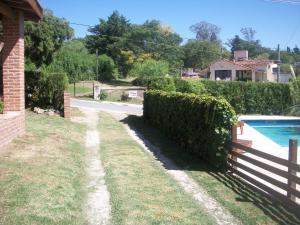 einen Garten mit einem Zaun und einem Pool in der Unterkunft Cabañas Tio Willy in Villa Carlos Paz