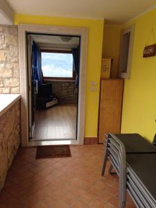 cocina con puerta que da a una sala de estar en Appartamento Soldo, en Castelletto di Brenzone