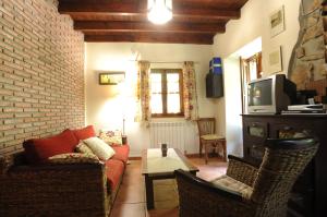 a living room with a couch and a tv at Río Aliso in Llonín