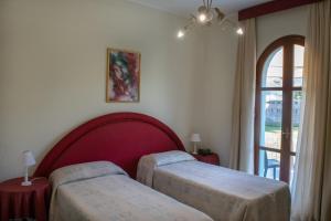 a hotel room with two beds and a window at Hotel Porto Azzurro in Giardini Naxos