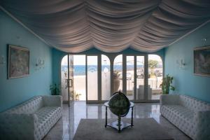 a living room with two couches and a large window at Hotel Porto Azzurro in Giardini Naxos