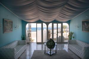 een woonkamer met 2 banken en een groot raam bij Hotel Porto Azzurro in Giardini Naxos