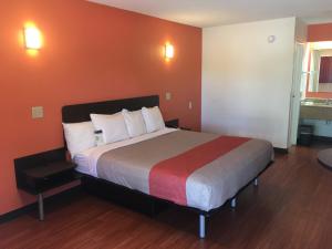 - une chambre avec un grand lit et un mur rouge dans l'établissement Motel 6-Richmond, VA - Midlothian Turnpike, à Richmond