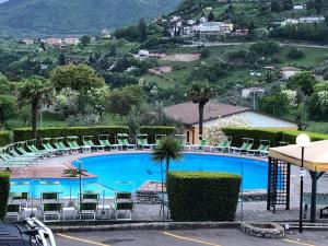 a view of a swimming pool with chairs and a mountain at Casa negli Ulivi in Tremosine Sul Garda