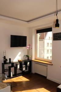 a living room with a tv and a window at Apartament Targ Rybny LUXON Gdansk in Gdańsk