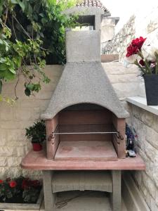 a wooden bench sitting in a garden with flowers at Apartman Crnica in Šibenik