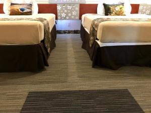 two beds in a room with a carpet at Lake View Suites in West Yellowstone