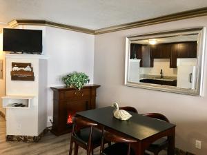 a living room with a table and a mirror at Lake View Suites in West Yellowstone